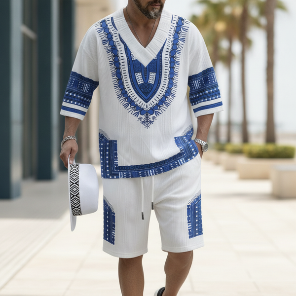 A man in a vibrant patterned V-neck top and matching shorts walks confidently outdoors, showcasing the relaxed fit of the sum