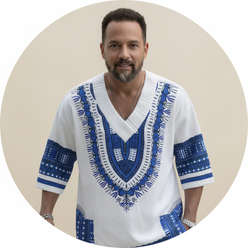 Julian Banks, a masculine person, smiling in a circular portrait, wearing a printed V-neck top from the EXARUS summer set aga